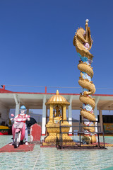 Statues of man on motorcycle, sitting angle and dragon under blue sky