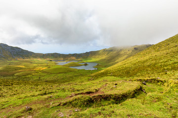 Hiking trail winds its way down in the center of the Corvo Caldera on the island of Corvo in the Azores, Portugal.