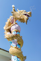 Golden dragon's head at the temple with blue sky background.
