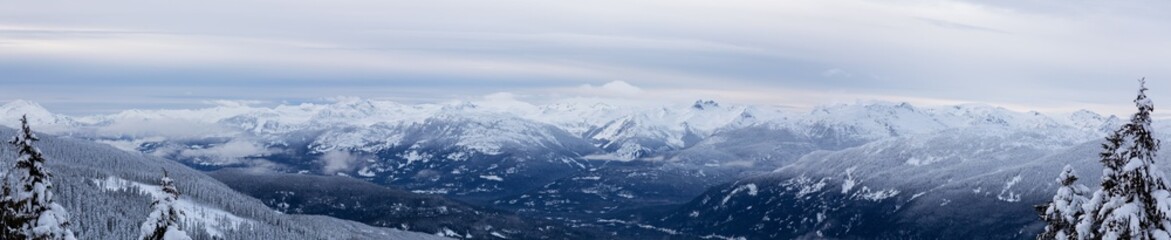 Fototapeta na wymiar Whistler, British Columbia, Canada. Beautiful Panoramic View of the Canadian Snow Covered Mountain Landscape during a cloudy and foggy winter evening.