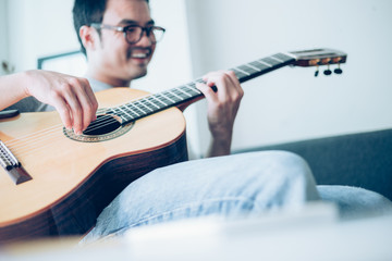artist playing acoustic guitar,sing folk song.happy man sitting enjoy on sofa in relax time.concept...