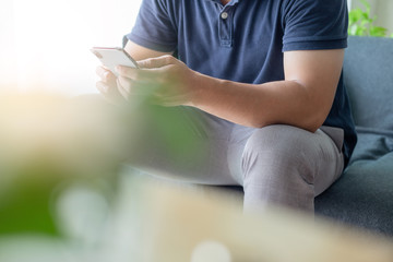 using cell phone.hand holding texting message on screen mobile chatting friend ,search internet information sitting on sofa in office.technology device contact communication connecting people concept