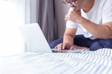 using computer.asian man hand typing message keyboard laptop shopping online.search information form internet while sitting on sofa.concept use technology device contact communication business