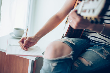 artist songwriter thinking writing notes,lyrics in book at studio.man playing live acoustic guitar relax chill.concept for musician creative.composer work process.people relaxing time with instrument