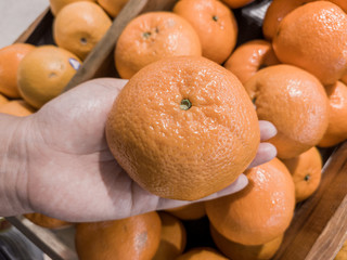 Close up Hand and Oranges in market.mandarin oranges raw Fruit,Fresh mandarin oranges texture