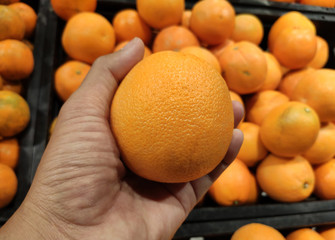Close up Hand and Oranges in market.mandarin oranges raw Fruit,Fresh mandarin oranges texture