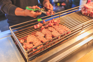 Beef Steak Dice Cooking. Grilled beef on charcoal stove and cutting. Diced Beef Steak Japanese Style. Saikoro Steak. Asian street food night market. Regional Food