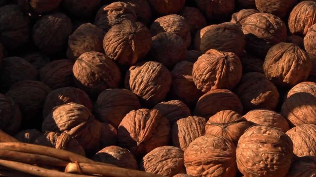 Close up walnuts inside wicker basket. pan right
