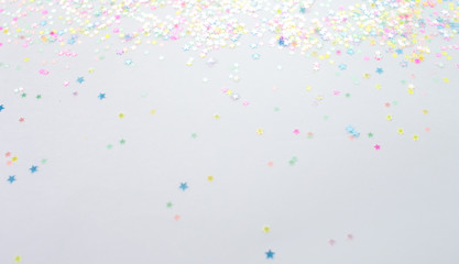 Gold stars confetti abstract pattern on a white background. Holiday concept, top view.