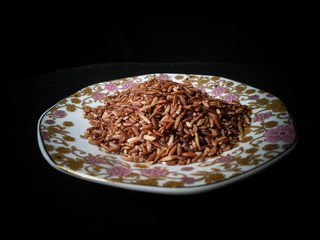 Red/brown rice isolated on black background