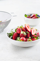Bowl of fresh strawberries on white background
