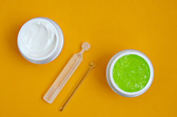 face cream, serum, aloe gel mask, on a yellow background, close-up