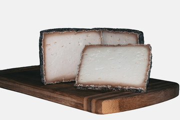 A cut goat cheese head with blurred background, white background