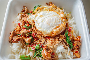 Rice topped with basil fried chicken and fried egg.