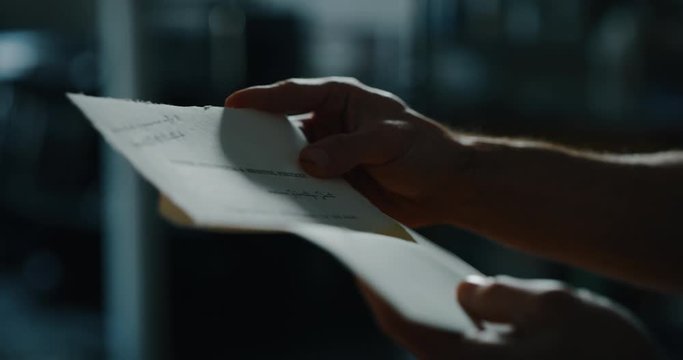 Cinematic close up shot of man is closing a letter before sending it. Concept of correspondence, calligraphy, communication