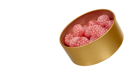 Pink raspberry candies in metal box. Delicious fruit caramel sweets in container.