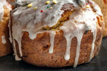 rustic cakes with icing. Glaze flows down white smudges with colored powders and sweets close-up. Symbol of Russian Easter in bright sunlight. Easter card
