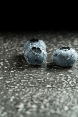 Вlueberries covered with drops of water on a gray background