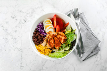 Clean food and dieting nutrition concept. Lunch bowl with chicken, egg, tomatoes, lettuce, corn, red beans, red cabbage. Top view, copy space, flat lay
