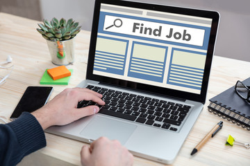 Man working with a laptop, find job on the screen, office business background.