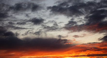 Naklejka na ściany i meble Sunrise clouds. Dramatic magical sunset over orange cloudy sky