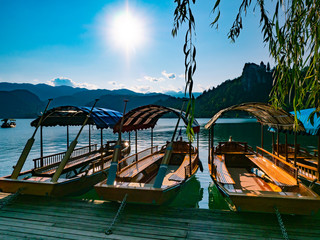 wooden tourist boats on Lake Bled in Slovenia during a summer day with the sun