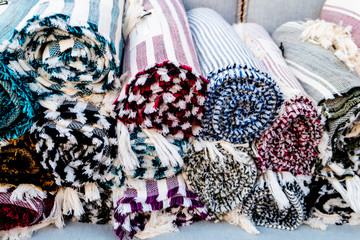 colorful cloth rugs rolled up in a Greek market