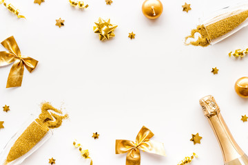 New Year mockup in gold color. Champagne bottle, present box, decoration on white background top-down frame copy space