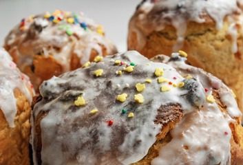 rustic cakes with icing. Glaze flows down white smudges with colored powders and sweets close-up. Symbol of Russian Easter in bright sunlight. Easter card