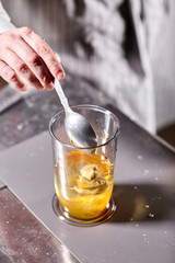 The chef adds mustard. Beating of homemade mayonnaise with olive oil. Mix ingredients for sauce. The chef uses a blender. Step by step sauce preparation
