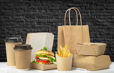 Fast food big lunch packaging set on black brick wall background.