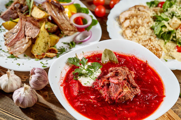 Red beet vegetable soup borscht on wooden background. Ukrainian and russian national food. Close-up.