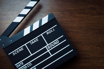 movie clapper cinema board or Slate film.Clapperboard for filmmaking and video production to assist in synchronizing of picture ,sound on Wooden Floor Tiles background.cinema concept