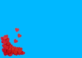 heap of wooden heart placed on the corner of paper template on blue background, valentine and wedding concept.
