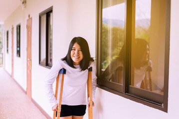 Asian women patient using crutches and broken leg for walking at home