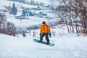 Fototapeta na wymiar man snowboarding down by hill