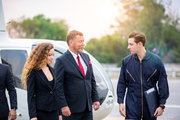 Business people greeting clients near small private helicopter on a landing point