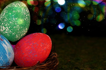 beautiful multicolored Easter eggs in a wicker basket on a shiny background