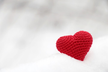 Valentine heart in winter forest. Red knitted heart, symbol of romantic love in the snow, concept of Valentines day