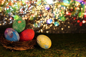 beautiful multicolored Easter eggs in a wicker basket on a shiny background