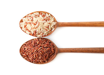 Brown and polished rice in spoons isolated on white, top view