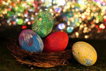 beautiful multicolored Easter eggs in a wicker basket on a shiny background