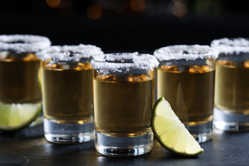 Mexican Tequila shots, lime slices and salt on bar counter