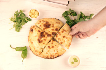 Stuffed naan desi pizza with herbs vegetables and dips.