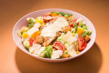 Fresh ceasar salad with vegetables on a color background