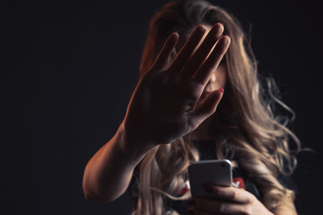 Tired sad teenage girl bullying, front view of scared teenager tired of bullying in social networks, cyber bullying by mobile phone