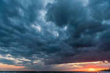 Dramatic dark orange red sunset cloudscape skyscape in Santa Rosa Beach, Florida with Pensacola coastline coast skyline in panhandle with ocean gulf mexico