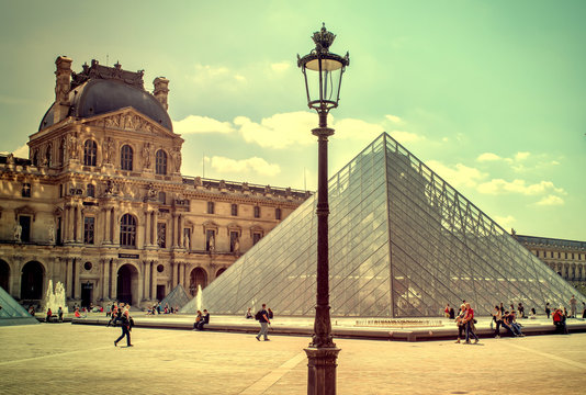 Paris, FRANCE - MAY 27, 2015: The Louvre in Paris on a sunny day with blue sky. Most famous museum goes back 800 years of continuous transformations from fortress to palace and today museum.