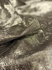 fabric draped on the table with folds and iridescent surface, shine, bruise, beams, background