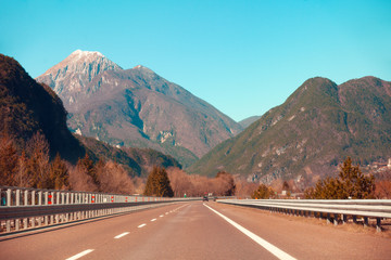 View of beautiful mountain landscape through the windscreen on a sunny day. Driving a car on mountain winding road in National park Picos de Europa. Cantabria, Spain, Europe